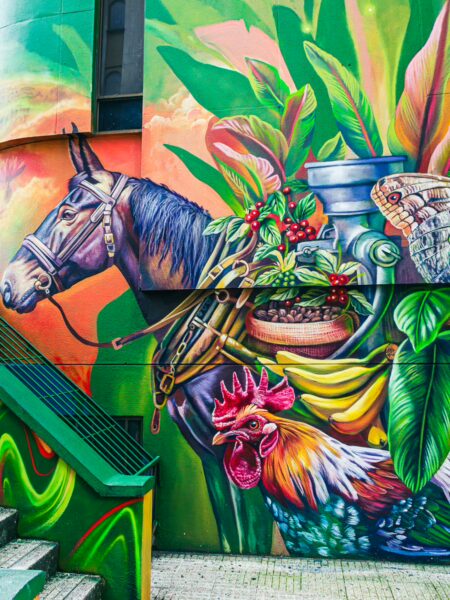 Vibrant mural depicting a horse and rooster amidst tropical plants, showcasing colorful details in Santa Rosa de Cabal, Risaralda, Colombia.