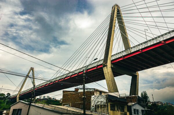 Viaducto de Pereira showcases a modern cable-stayed bridge with a bold red and gray design set against a cloudy sky in Risaralda, Colombia.
