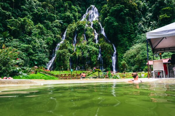 Relaxing waters of Termales de Rosa, surrounded by lush greenery and cascading waterfalls in Risaralda, Colombia.