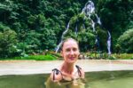 Relaxing in Termales del Ruiz's thermal waters, surrounded by lush greenery and a stunning waterfall in Risaralda, Colombia.