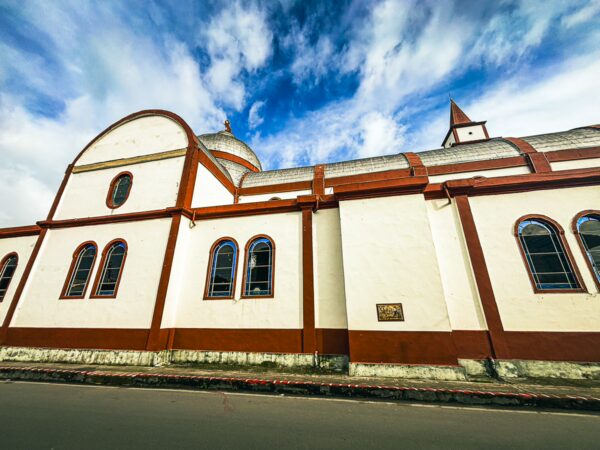 Milagrosa church features a white and red facade under a blue sky, showcasing its elegant architecture in Murillo, Tolima, Colombia.