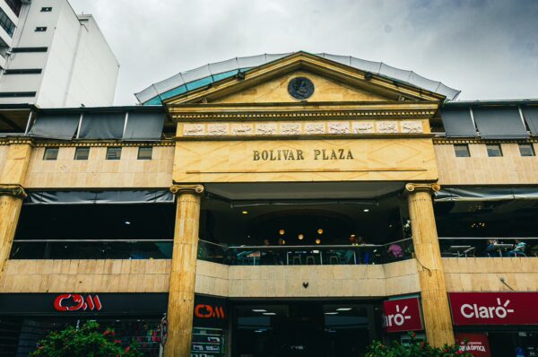 Bolivar Plaza, a striking golden façade with classic columns, showcases vibrant storefronts in Pereira, Risaralda, Colombia.