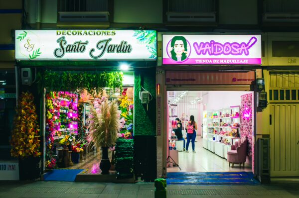 Colorful storefronts featuring floral decor at Santo Jardín and stylish beauty products at Vaidosa in Santa Rosa, Risaralda, Colombia.