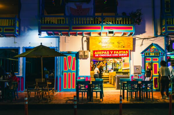 Vibrant storefront at Parque Bolivar, Filandia, Quindio, Colombia, featuring colorful architecture and outdoor seating.