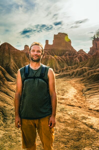 A traveler stands in the unique landscape of the Tatacoa Desert, showcasing its striking red and brown hills in Huila, Colombia.