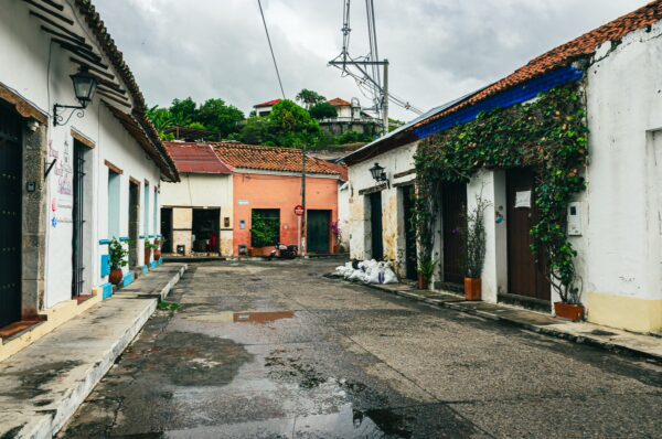 Charming streets of Honda, Tolima, Colombia feature colorful houses, lush green vines, and a tranquil, rainy atmosphere.