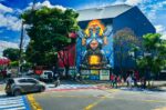 Colorful street art adorns a building in Pereira, Risaralda, Colombia, with a vibrant mural and bustling city life.