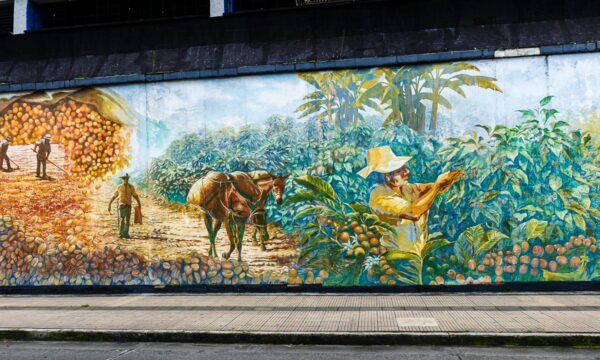 Vibrant mural depicting coffee cultivation scenes in Quindío, Colombia, featuring farmers, horses, and lush greenery.