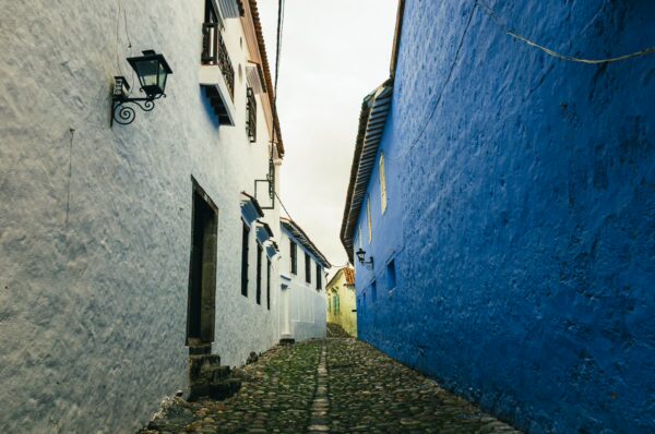 Colorful cobblestone alleyway with blue and white walls in Honda, Tolima, Colombia, showcasing charming colonial architecture.