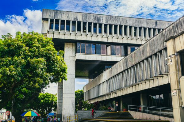 Modern architecture contrasts with lush greenery at the city center of Pereira, Risaralda, Colombia, under a blue sky.