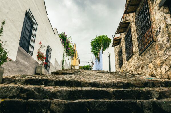 Calle de Las Trampas Honda features cobblestone steps leading through colorful houses and lush greenery in Tolima, Colombia.
