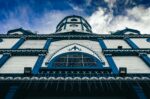 Inmaculada Concepción church features striking blue and white architecture under a dramatic sky in Filandia, Quindío, Colombia.