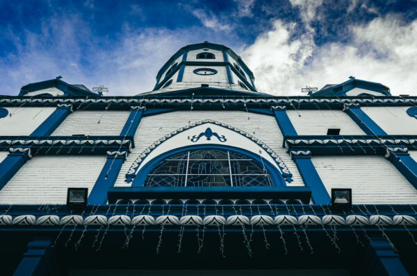 Inmaculada Concepción church features striking blue and white architecture under a dramatic sky in Filandia, Quindío, Colombia.