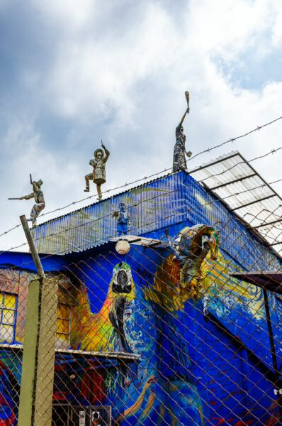 Colorful mural with sculptures atop a blue building, featuring vibrant designs in Quindio, Colombia.