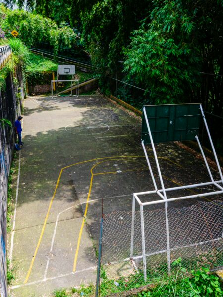 A vibrant, open soccer field in Quindío, Colombia, with white goalposts and green foliage surrounding the area.