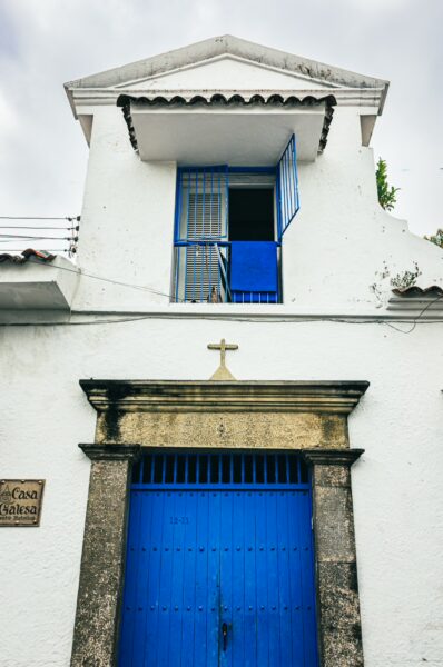 White colonial building with a vibrant blue door and window, showcasing Tolima’s charming architecture in Colombia.