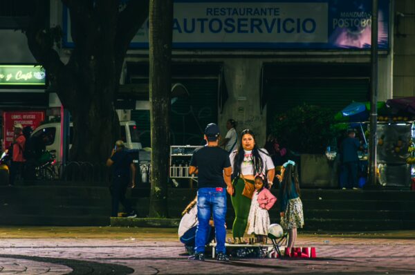 Vibrant scene at Plaza de Bolívar with vendors and families enjoying the evening atmosphere in Pereira, Risaralda, Colombia.