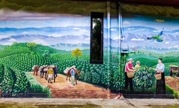 Vibrant mural depicting coffee farmers and lush green hills at Parque de la Vida in Armenia, Quindío, Colombia.