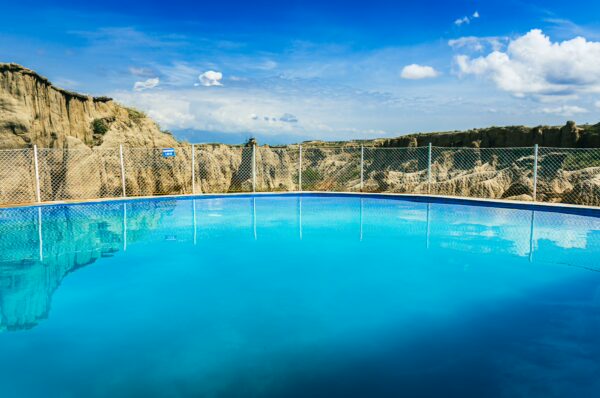 Vibrant blue pool reflecting the sky, surrounded by the unique landscapes of Los Hoyos in Tatacoa Desert, Huila, Colombia.