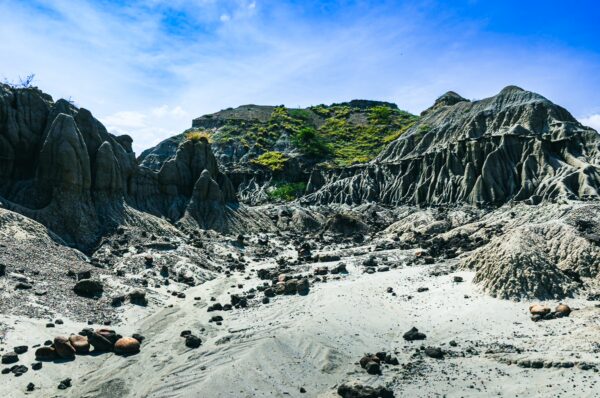 Unique rock formations and arid landscape contrast against vibrant blue skies in Los Hoyos, Tatacoa Desert, Huila, Colombia.