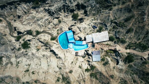 Aerial view of a turquoise pool surrounded by rocky terrain in the Los Hoyos area of Tatacoa Desert, Huila, Colombia.