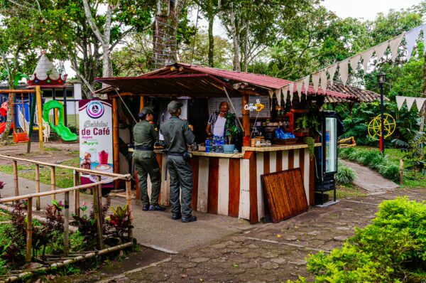 Colorful stall at Parque de la Vida in Armenia, Quindío, with patrons interacting and vibrant decorations in the background.