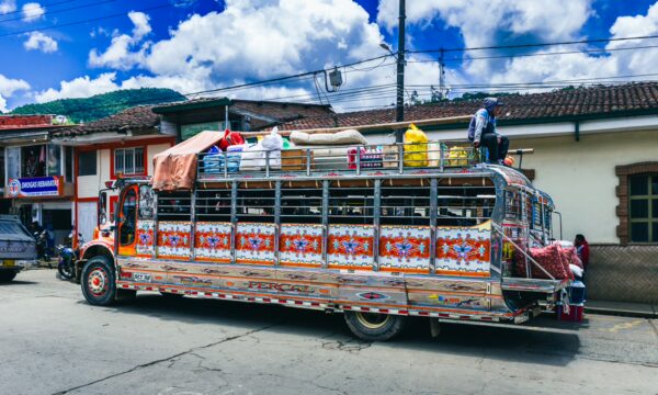 Colorful bus adorned with vibrant decorations parked in a lively street of Parque Principal Silva, Cauca, Colombia.