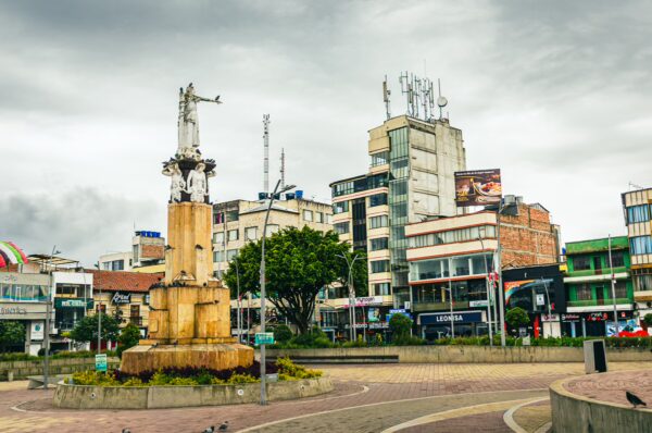Plaza La Pola features a prominent statue and modern buildings, surrounded by greenery in Ipiales, Nariño, Colombia.