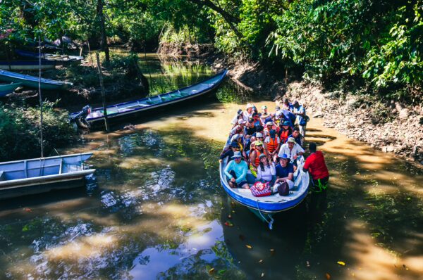Colorful boats and tourists enjoy a scenic ride through the lush greenery of the natural pool in Ladrilleros, Valle del Cauca, Colombia.