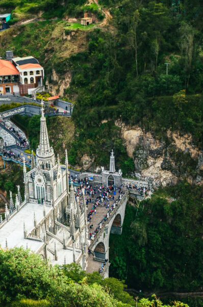 Stunning view of Las Lajas Sanctuary, showcasing its towering spires and surrounding lush green hills in Nariño, Colombia.