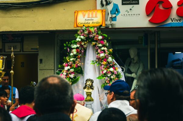 Colorful floral decorations frame a religious statue celebrated during a procession in Ipiales, Nariño, Colombia.