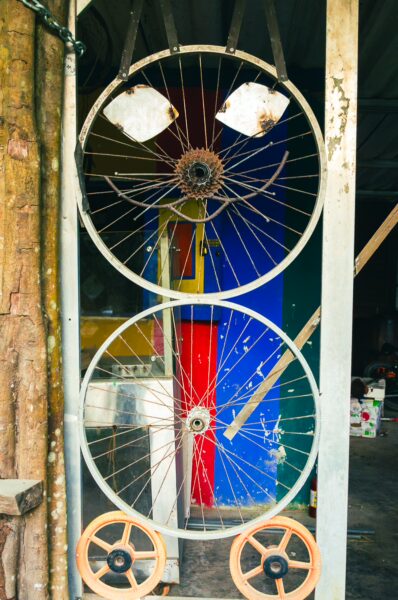 Colorful bicycle wheels create a unique entrance in Ladrilleros, showcasing local creativity and vibrant colors typical of Valle del Cauca, Colombia.