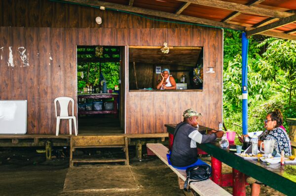 Chucheros Beach features a rustic eatery with diners enjoying meals, surrounded by lush greenery in Uramba, Valle del Cauca.
