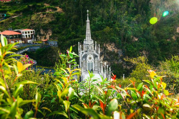 Breathtaking view of Las Lajas Sanctuary surrounded by lush greenery in Nariño, Colombia, with its striking Gothic architecture.