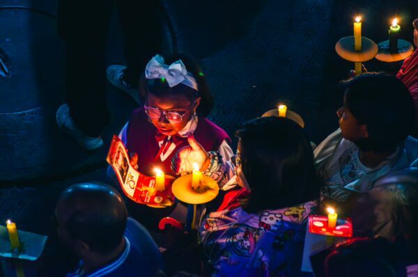 Children holding candles during a vibrant celebration in Popayán, Cauca, Colombia, showcasing colorful attire and festive spirit.