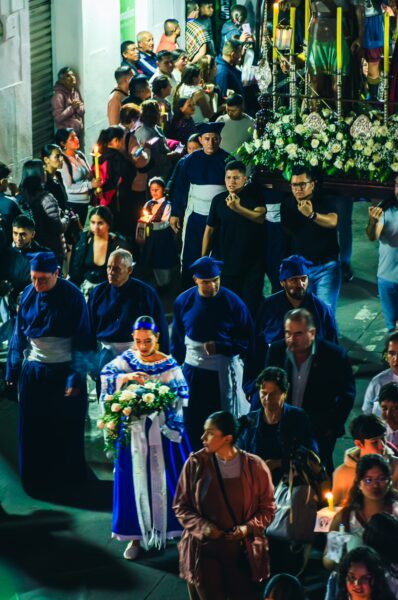 Colorful procession in Popayán, Cauca, Colombia, featuring traditional costumes, flowers, and a vibrant crowd during a festive event.