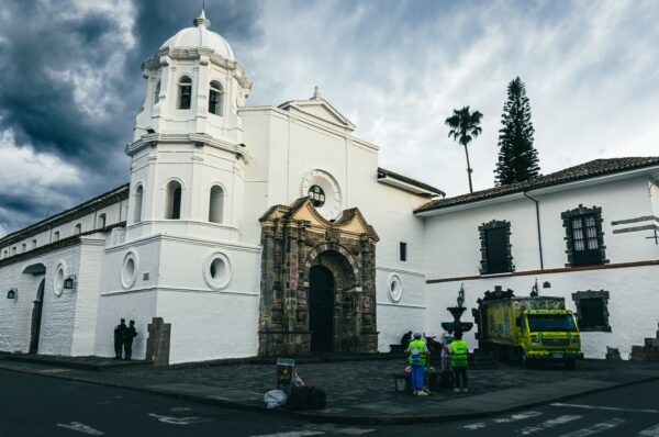Claustro de Santo Domingo features a white facade and a striking bell tower, set against a dramatic sky in Popayán, Cauca, Colombia.