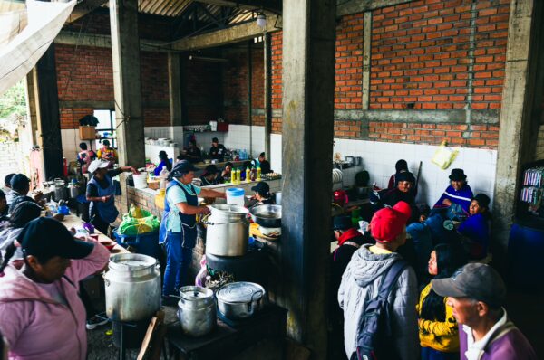 Vibrant market scene in Cauca, Colombia, with local vendors preparing food and customers bustling around colorful stalls.