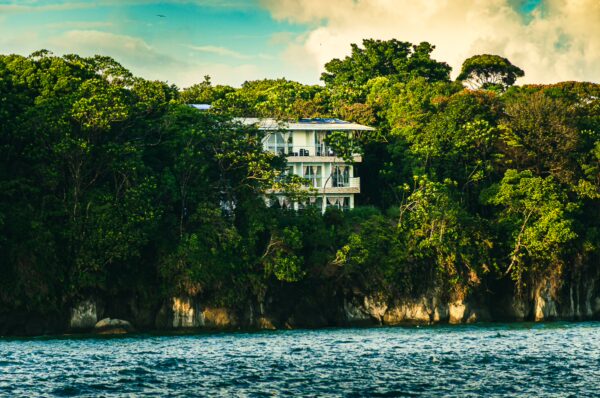 Serene waterfront view featuring a stylish house nestled among lush greenery in Juanchaco, Valle del Cauca, Colombia.