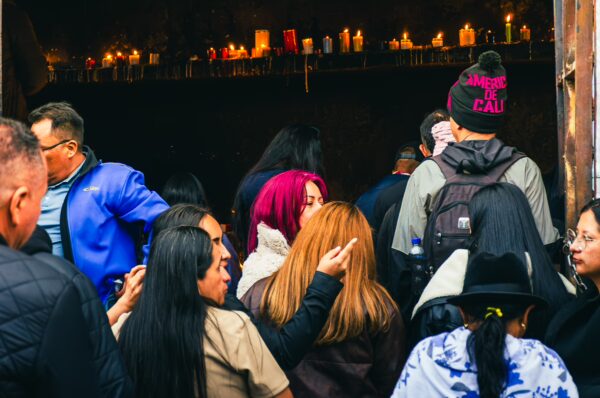 Crowd of visitors inside the Las Lajas Sanctuary, with colorful candles glowing in the background, Narino, Colombia.