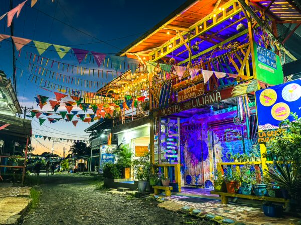Colorful decorations and vibrant lights adorn a lively building in Juanchaco, Valle del Cauca, Colombia, creating a festive atmosphere.