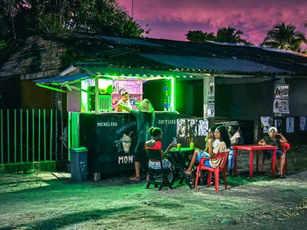 Vibrant scene at a Juanchaco food stand in Valle del Cauca, Colombia, with locals enjoying the evening atmosphere under colorful lights.