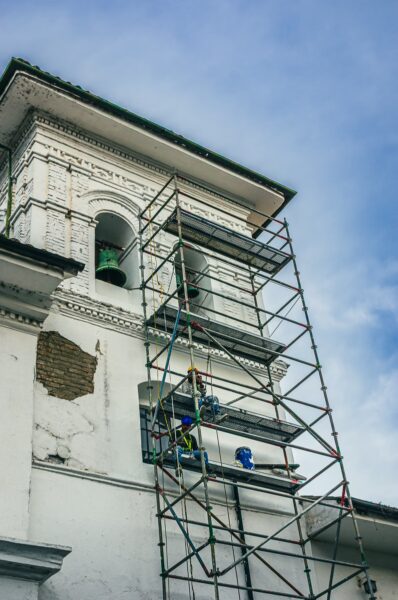 Scaffolding surrounds the Templo de la Encarnación, showcasing ongoing restoration against a blue sky in Popayán, Cauca, Colombia.