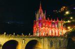 Las Lajas Sanctuary illuminated at night, showcasing its intricate architecture and vibrant colors over the bridge in Nariño, Colombia.