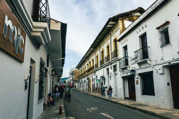 Charming colonial architecture lines the narrow street in Popayán, Cauca, Colombia, showcasing vibrant colors and intricate details.