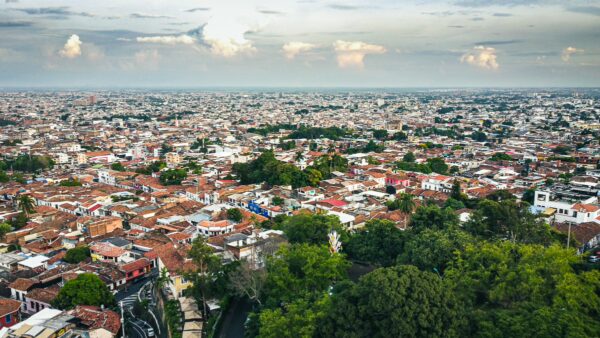 Expansive view of terracotta rooftops and lush greenery in Cali, Valle del Cauca, showcasing the city’s vibrant landscape.