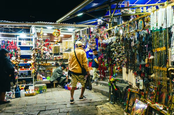 Colorful market stalls display a variety of handcrafted items and souvenirs in Las Lajas, Narino, Colombia, under night lighting.