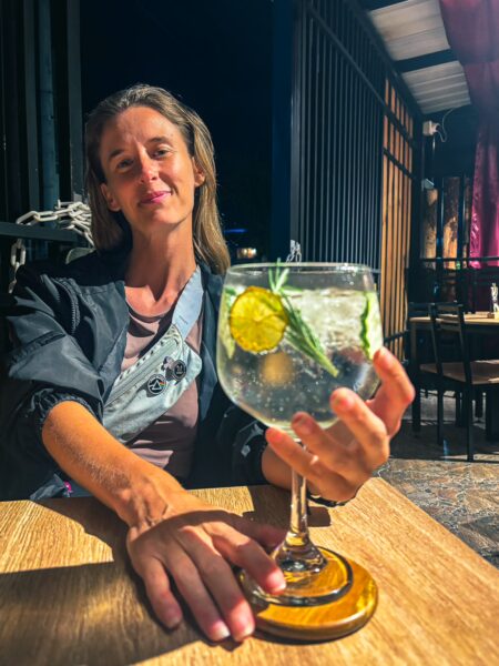 Roux Pizza in Popayán, Cauca, Colombia showcasing a woman holding a large cocktail with a lemon slice and green garnish.