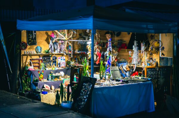 Vibrant artisan market stall illuminated at night in Popayán, Cauca, showcasing colorful crafts and local handmade goods.