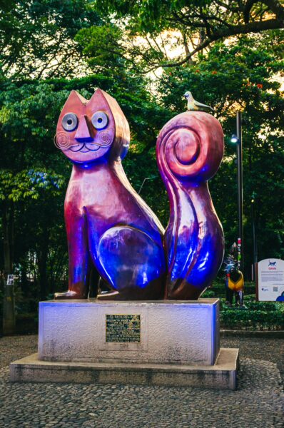 Colorful cat statue illuminated at Parque del Gato de Tejada, a whimsical landmark in Cali, Valle del Cauca, Colombia.